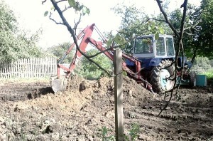 Трактор копает землю