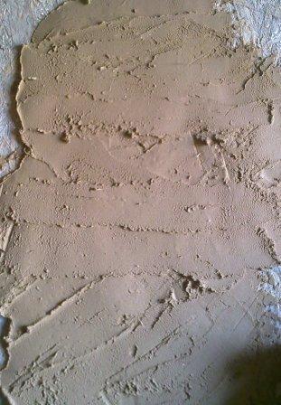 Свежий глиняно-песчаный раствор нанесен на стену
